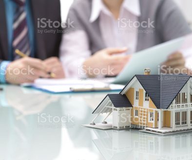Businessman signs contract behind home architectural model