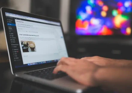Person creating a blog post at a desk in front of a computer
