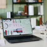 Laptop showing website analytics and charts on a desk